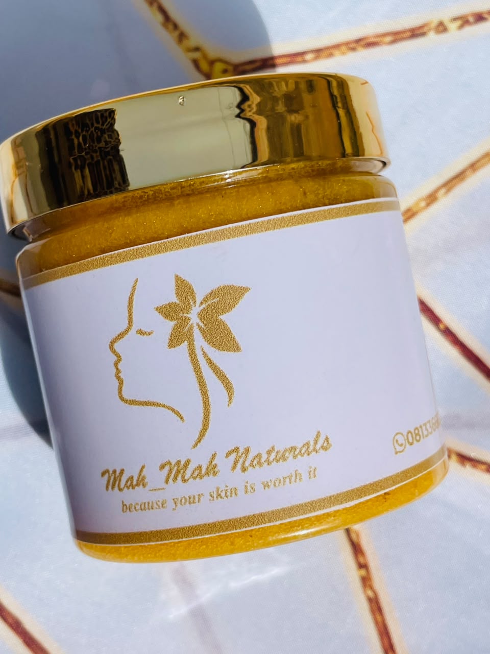 MahMah Naturals body scrub in a gold-lidded jar